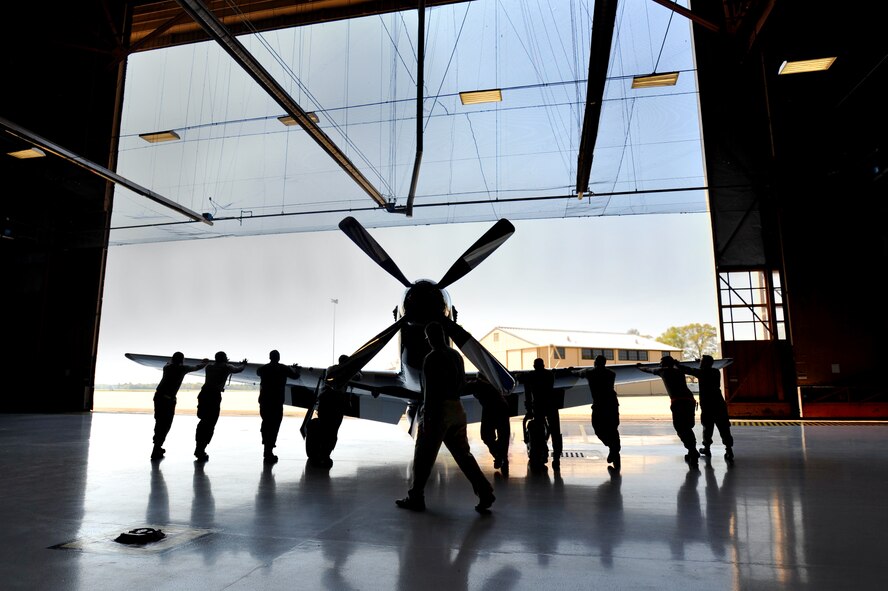 U.S. Air Force Airmen assigned to the 20th Aircraft Maintenance Squadron, help push a P-51 Mustang out of a hanger prior to takeoff, Shaw Air Force Base, S.C., March 19, 2012. The P-51 Mustang "Quick Silver" was restored more than 13 years ago by father and son Bill and Scott Yoak. Yoak's P-51 Mustang will be one of the many aircraft that will perform during the upcoming Shaw Air Expo, May 5-6. (U.S. Air Force photo by Senior Airman Kenny Holston/Released)

