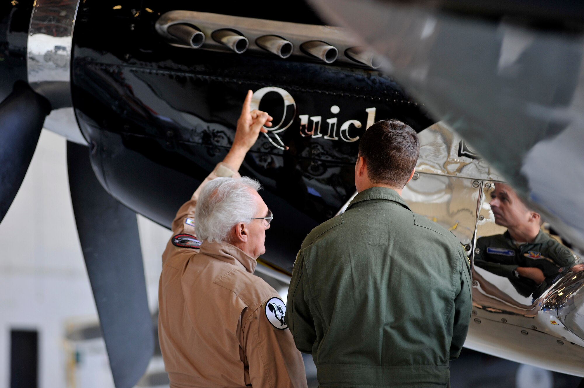 Mr. Bill Yoak, P-51 Mustang owner and crew chief, explains the functions of the P-51 to Col. Charlie Moore, former 20th Fighter Wing commander, after a 20th FW change of command ceremony, Shaw Air Force Base, S.C., March 19, 2012. The P-51 Mustang "Quick Silver" was restored more than 13 years ago by father and son Bill and Scott Yoak. Yoak's P-51 Mustang will be one of the many aircraft that will perform during the upcoming Shaw Air Expo, May 5-6. (U.S. Air Force photo by Senior Airman Kenny Holston/Released)

