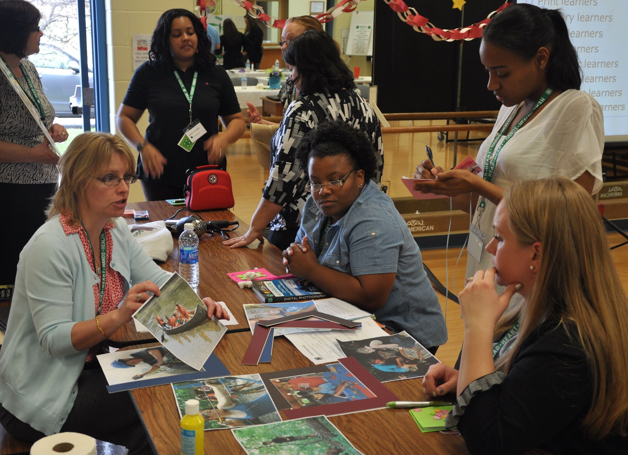 Susan Long, Air Mobility Command child and youth specialist, left reviews the photograph curriculum during the skill-a-thon, part of the 4-H “101” training held March 13-16, 2012, at Scott Air Force Base, Ill., with youth development professionals Brooke Matthews, Joint Base Charleston, S.C.; Kashante Whitaker, Dover AFB, Del.; and Kristina Mueller, Scott AFB, Ill. The 4-H 101 training program highlights the delivery and support of 4-H youth development and the ability for Air Force Youth Programs to engage with each state's land-grant university in offering high quality programming. (U.S. Air Force photo/James L. Hodges)