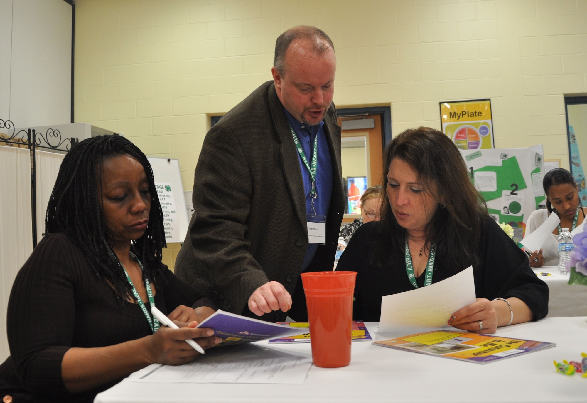 David Brittain, center, 4-H youth development specialist at Headquarters Air Mobility Command, discusses a curriculum with youth development professionals Precious Cox, Scott Air Force Base, Ill., and Vicki Wargo, Joint Base McGuire-Dix-Lakehurst, N.J., during 4-H “101” training held March 13-16, 2012, at Scott AFB, Ill. The 4-H 101 training program highlights the delivery and support of 4-H youth development and the ability for Air Force Youth Programs to engage with each state's land-grant university in offering high quality programming. (U.S. Air Force photo/James L. Hodges)