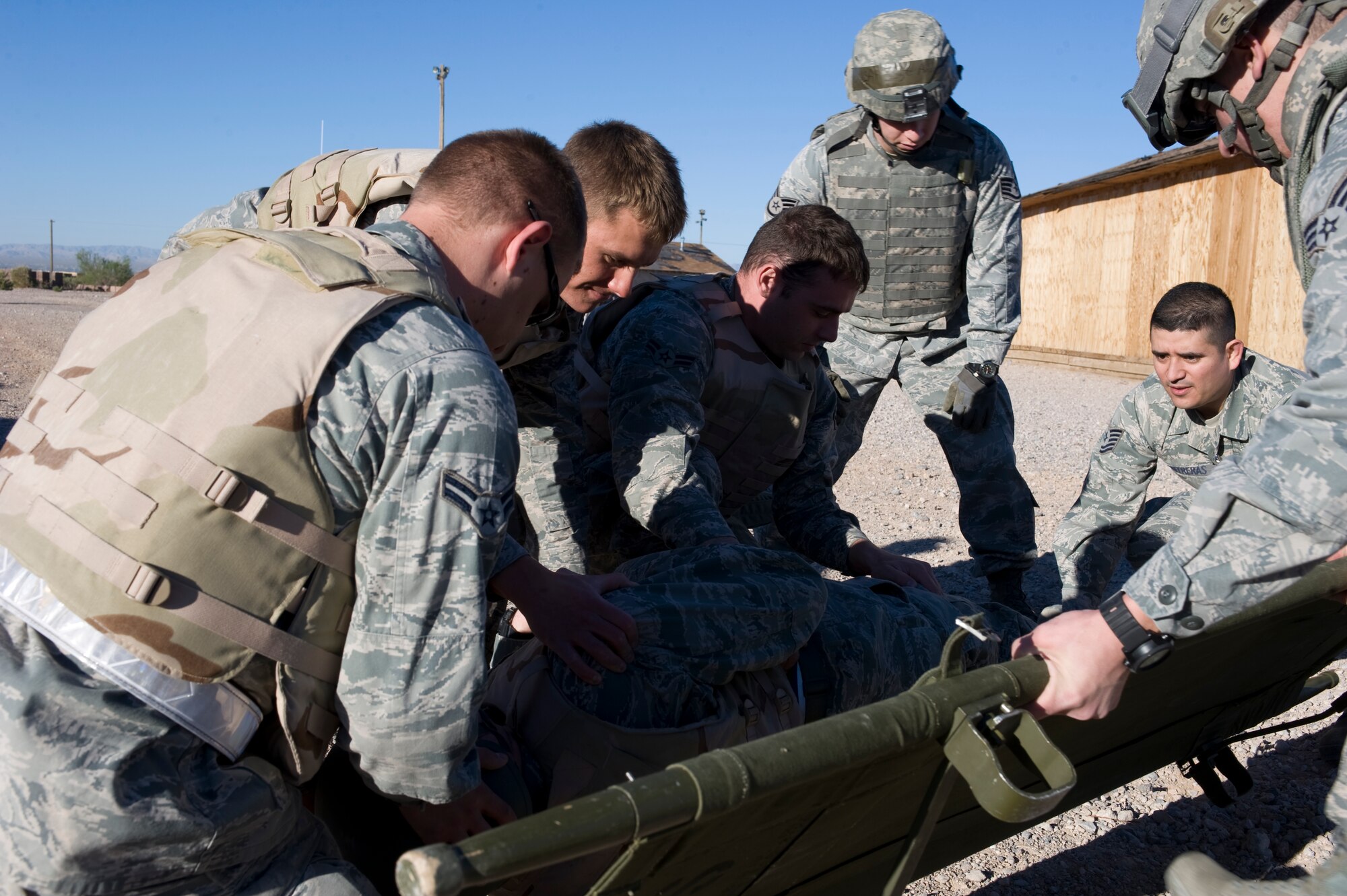 U.S Air Force TSgt Luis Contreas, 99th Medical Group orthopedic technician, shows Airmen how to put a simulated casualty on a litter during an Operational Readiness Exercise located at Camp C.O.B.R.A. March 21, 2012, at Nellis Air Force Base, Nev. Being able to provide self aid and buddy care was one of the tasks that were trained and evaluated during the exercise. (U.S. Air Force photo by Airman 1st Class Matthew Lancaster)
