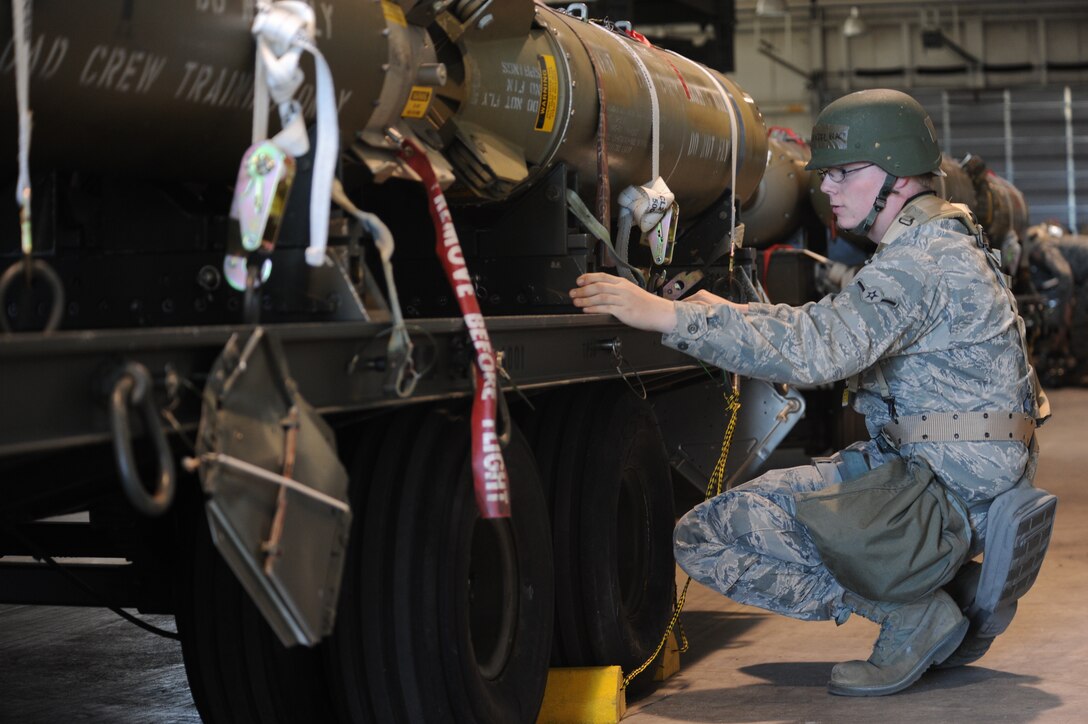 Airman Daniel Black, 28th Munitions Squadon munitions, tightly secures inert cluster bomb units during an Operational Readiness Exercise at Ellsworth Air Force Base, S.D., March 15, 2012.   MUNS personnel are responsible for safely building, loading, transporting and securing the bomb units for transport.  (U.S. Air Force photo by Airman 1st Class Anania Tekurio/Released)
