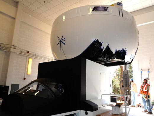 A 2,200 pound visual dome is moved into place to fit over the cockpit portion of a new T-1A Jayhawk flight simulator March 14 at Vance Air Force Base, Okla. Flight simulators are an important part of training more than 400 U.S. Air Force, Navy, Marine Corps and allied student pilots each year at Vance AFB. (U.S. Air Force photo/ Airman 1st Class Frank John Casciotta)