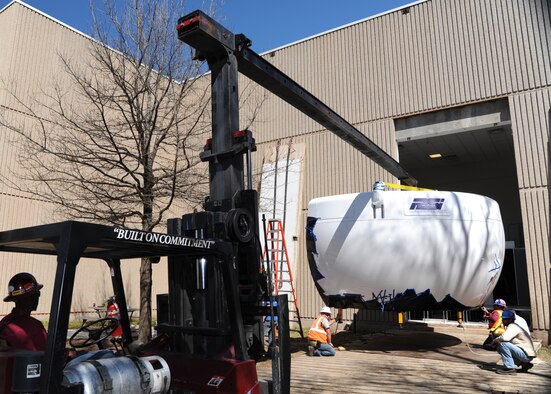 The 2,200 pound visual dome section of a new T-1A Jayhawk flight simulator is lifted through an exterior wall of the 71st Operations Group building March 14 at Vance Air Force Base, Okla. The dome will provide 240 degrees of state-of-the-art visual flight and airfield simulation. The dome can generate images of more than 200 operational airfields and a variety of weather conditions. (U.S. Air Force photo/ Airman 1st Class Frank John Casciotta)
