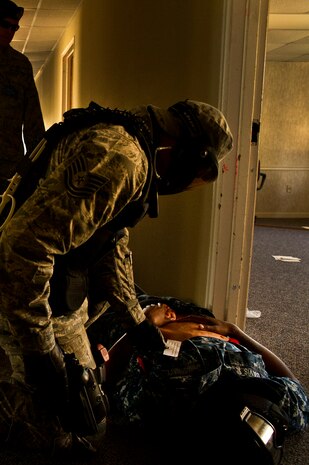 Tech. Sgt. Keith Lippy checks a body for signs of life during an active shooter scenario at Joint Base Charleston - Air Base March 20. During the active shooter scenario, the Anti-Terrorism/Force Protection exercise evaluated JB Charleston's capabilities in responding to a crisis situation. Sgt. Lippy is a 628th Security Forces Squadron patrolman. (U.S. Air Force photo by Airman 1st Class George Goslin)