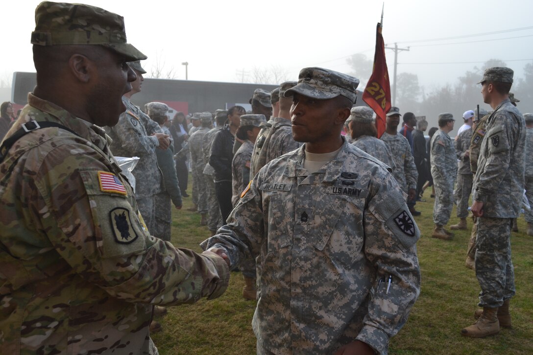 U.S. Army 1st Sgt. James Heatley, Headquarters and Headquarters Detachment first sergeant, 11th Transportation Battalion, 7th Sustainment Brigade, shakes heads with 1st Sgt. Joseph Hawkins, 119th Inland Cargo Transfer Company first sergeant, 11th Transportation Battalion, 7th Sustainment Brigade, one last time before the company deploys for 12 months to Afghanistan. The company will provide logistical support to deployed forces by overseeing a Central Receiving and Shipping Point. (U.S. Army photo by 1st Lt. Andrea Whitaker/Released)