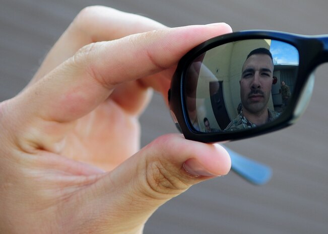 Staff Sgt. Kenneth Nelson, 9th Munitions Squadron technician, looks at his mustache in his sunglasses during a work break at the Beale AFB, Calif.,  bomb dump March 12, 2012. Many Airmen are growing mustaches in observance of Mustache March, which may have been started by Retired U.S. Air Force Brig. General Robin Olds. (U.S. Air Force photo by Senior Airman Shawn Nickel/Released)