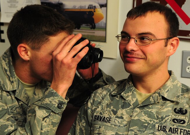 Staff Sgt. Chris Savage, 9th Civil Engineer Squadron explosive ordnance disposal technician, has his mustache inspected for growth by a fellow EOD technician in their flight Heritage Room March 12, 2012. Savage along with most of the EOD flight is growing the facial hair in observance of Mustache March. (U.S. Air Force photo by Senior Airman Shawn Nickel/Released)