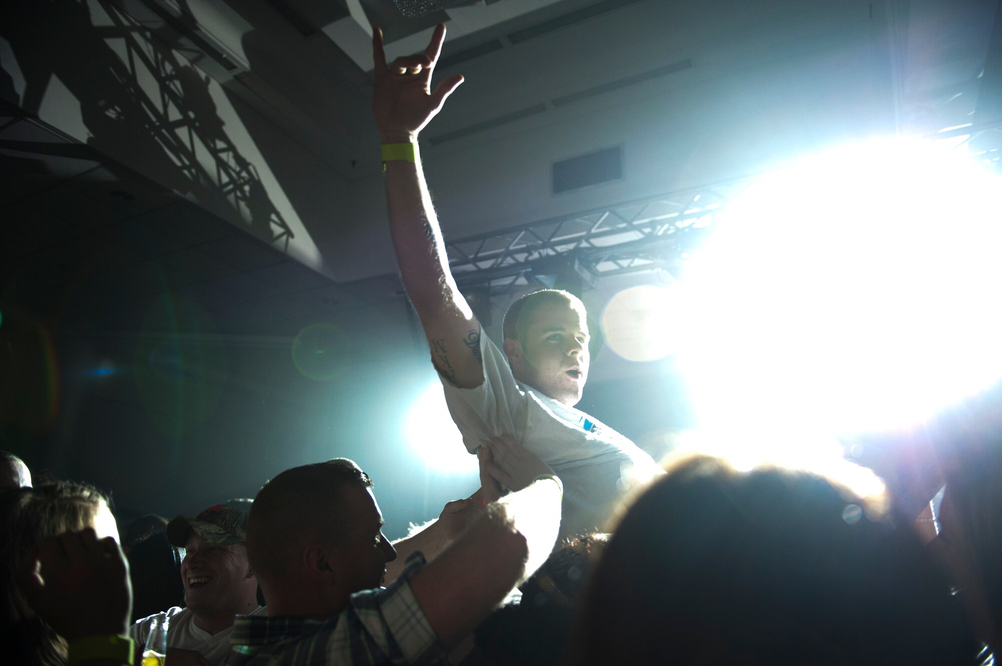 An Airman crowd surfs as the band Seether performs March 19, 2012, at the Club Complex at Incirlik Air Base, Turkey. The hard-rock band visited Incirlik as part of a USO tour through Italy and Turkey. (U.S. Air Force photo by Tech. Sgt. Michael B. Keller/Released)