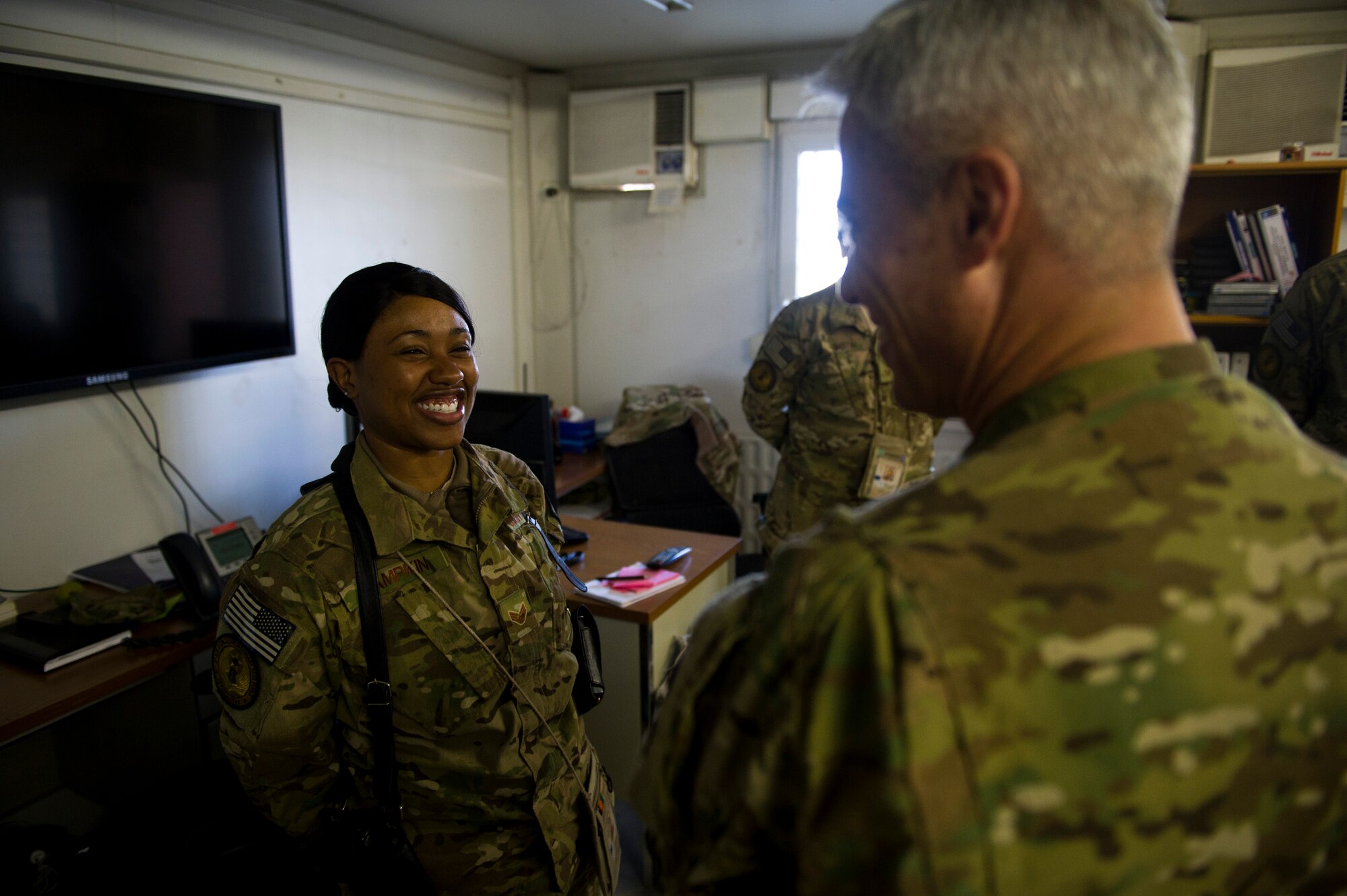 From left, Senior Airman Saleisa Lampkin, 9th Air and Space Expeditionary Task Force - Afghanistan, smiles and laughs as she talks to Chief Master Sgt. Robery Sealey, U.S. Air Forces Central command chief, at Kabul International Airport, Afghanistan on March 12, 2012. (U.S. Air Force photo by Staff Sgt. David Salanitri) 
