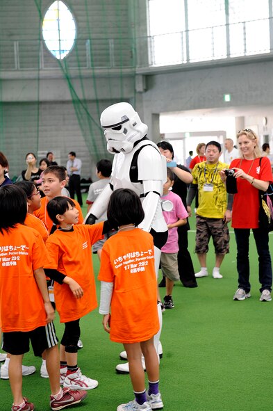 A Stormtrooper, of Star Wars fame, threw out the first ball of the dodge ball competition and posed for photos with the students as well as some volunteers throughout the sports day March 17, 2012, in Kadena Town, Japan. The event also featured tug-o-war teams and a sandal toss. (U.S. Air Force photo by Senior Master Sgt. J.C. Woodring/Released)