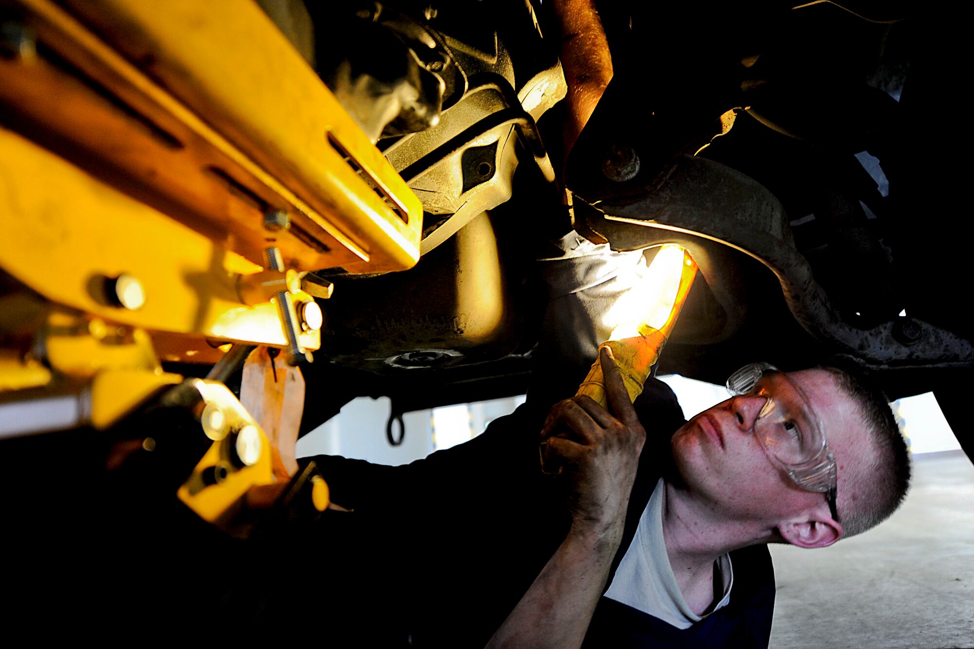 U.S. Air Force Senior Airman Craig Galvin, 18th Logistics Readiness Squadron vehicle maintenance journeyman, works on replacing the flex plate in a truck on Kadena Air Base, Japan, March 20, 2012. In order to fix the flex plate, Galvin must first remove the transmission. (U.S. Air Force photo by Airman 1st Class Brooke P. Beers/Released)