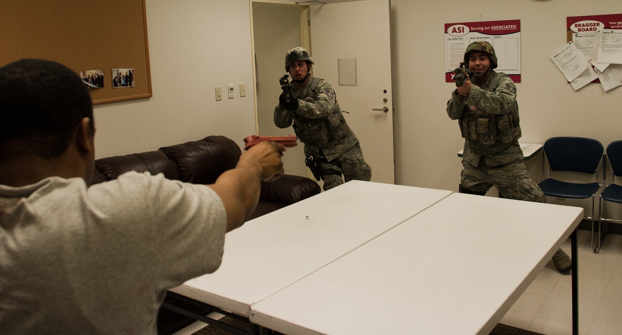 YOKOTA AIR BASE, Japan -- (Right), Staff Sgt. Justin Tanimoto, 374th Security Forces patrolman, and Staff Sgt. Carlos Sanchez, 374th SFS K-9 unit member, storm into a room during an active shooter scenario at Yokota Air Base, Japan, March 16, 2012. Security Forces teams used the Exchange, Commissary and several other locations around base for their training. (U.S. Air Force photo/Airman 1st Class John D. Partlow)