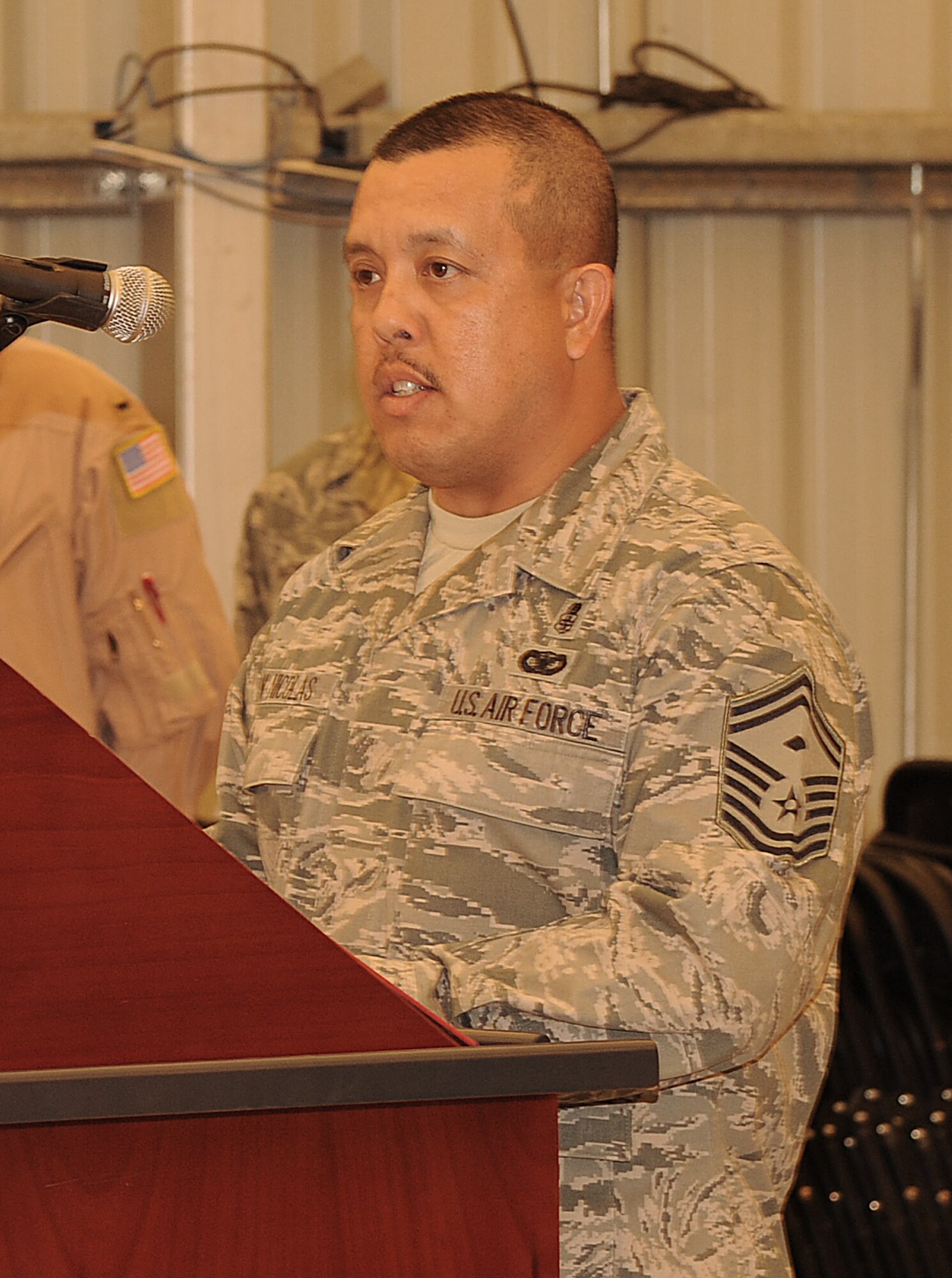 SOUTHWEST ASIA - Senior Master Sgt. Joseph San Nicolas gives a Christian reading at the 2012 National Prayer Luncheon at the Phantom Center March 20, 2012. Chaplain (Col.) Dondi E. Costin, Air Forces Central command chaplain, was the guest speaker at the event. San Nicolas is assigned to the 380th Expeditionary Security Forces Squadron.  (U.S. Air Force photo/Tech. Sgt. Arian Nead)
