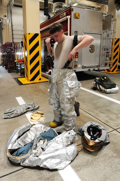 U.S. Air Force Airman 1st Class Jeremy Stephens, 35th Civil Engineer Squadron fireman, puts on his fire protection gear at Misawa Air Base, Japan, March 1, 2012. Firemen must put their gear on quickly and be ready to respond within a couple of minutes after being alerted. (U.S. Air Force photo by Kia Atkins/Released)
