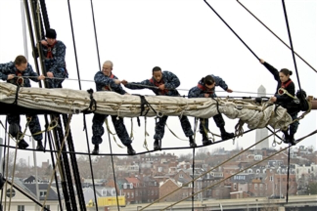 Navy sailors place the sail on the yard of the mizzenmast aboard the USS Constitution in Charleston, Mass., on March 14, 2012.  The sailors assigned to the Constitution routinely work to improve seamanship skills to prepare for possibly sailing the ship during the bicentennial of the War of 1812.  