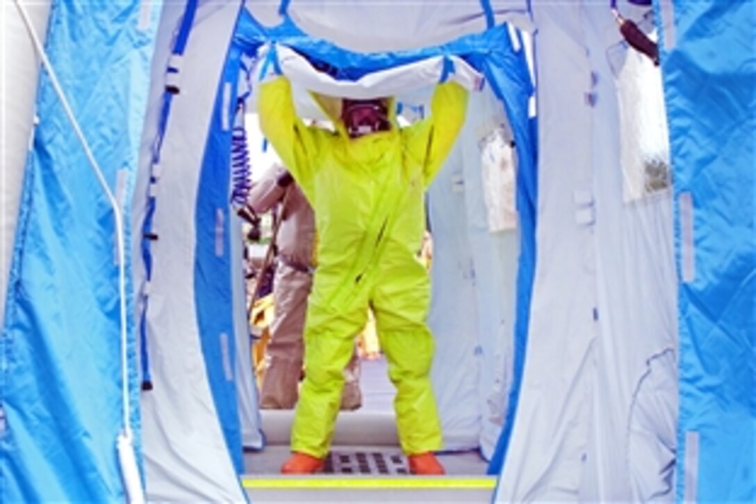 A member of the Navy Region Northwest Fire and Emergency Services Decontamination Team is washed down in a decontamination tent as a part of a hazardous material training scenario during Solid Curtain-Citadel Shield 2012 at Naval Base Kitsap-Bangor in Silverdale, Wash., March 20, 2012. The weeklong series of anti-terrorism and force protection exercises involves Navy installations and activities.