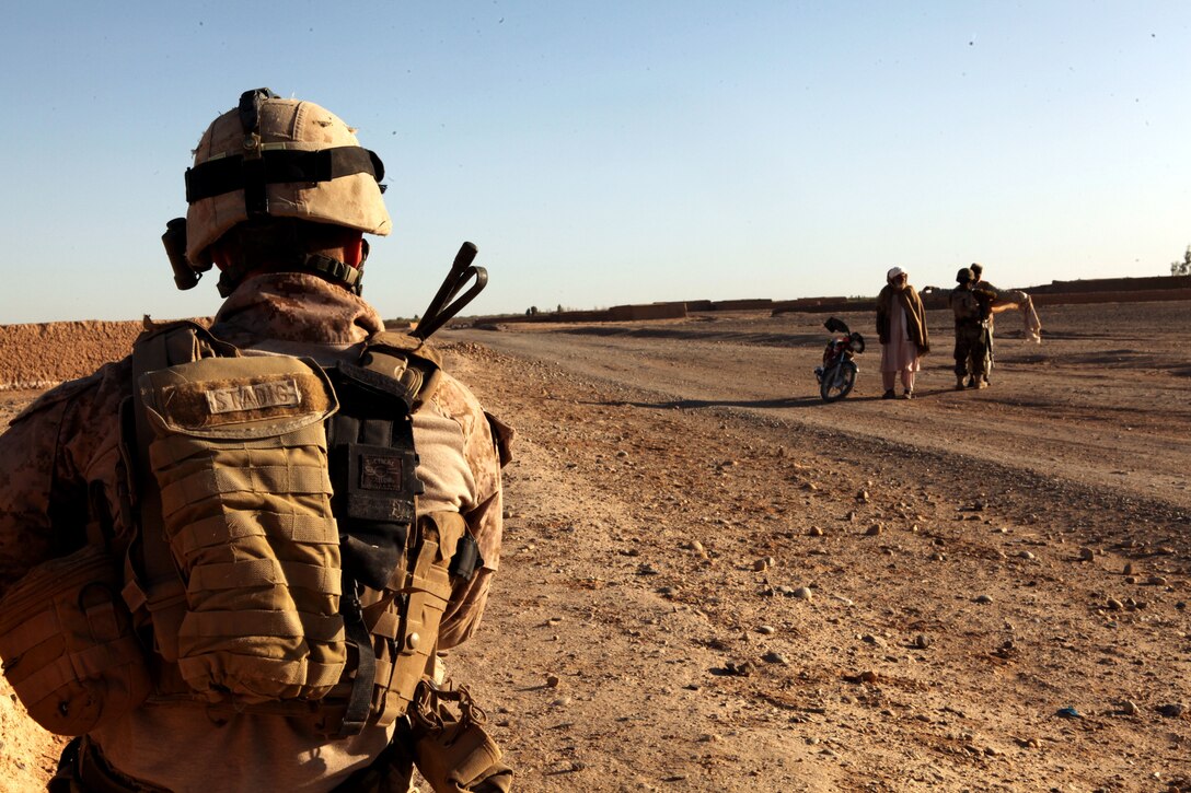 U.S. Marine Cpl. Glenn Stadig, a squad leader with Weapons Company, 2nd Battalion, 9th Marine Regiment, provides security for Afghan National Army soldiers with 3rd Kandak, 1st Brigade, 215th Corps, at a vehicle checkpoint here, March 22, 2012. In addition to advising Afghan forces in the blocks of Marjah, 2nd Bn., 9th Marines conducted partnered counternarcotics missions with the Afghan National Interdiction Unit in the Bari Desert during Operation Psarlay Taba. The partnered force captured around 26,000 pounds of assorted opium products over the course of the four-month operation.
