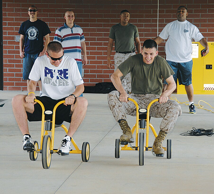 Marines participate in a tricycle race during the start of a barracks bash, March 14. The Single Marine Program sponsored the event for nearly 35 Marines and sailors who live in the barracks. Marine Corps Community Services catered the event and Enlisted Spouses Club members made cookies for the cookie eating contest. The Marines and sailors participated in other games including egg toss, water balloon toss, dizzy izzy, football and volleyball.
