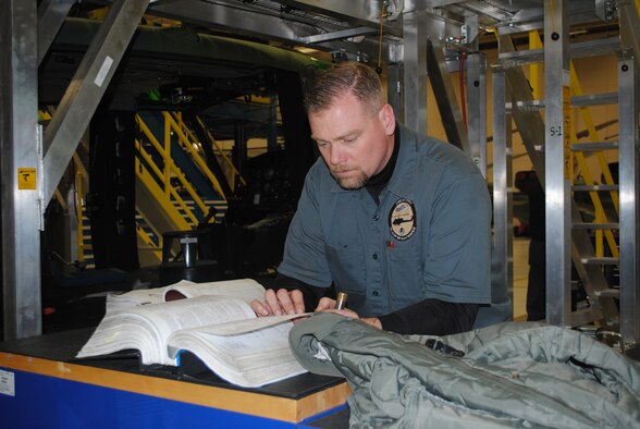 Kevin Mueller, 341st Maintenance Operations Squadron aircraft mechanic, reads technical data on transmission mounting. (U.S. Air Force photo/Airman 1st Class Katrina Heikkinen)