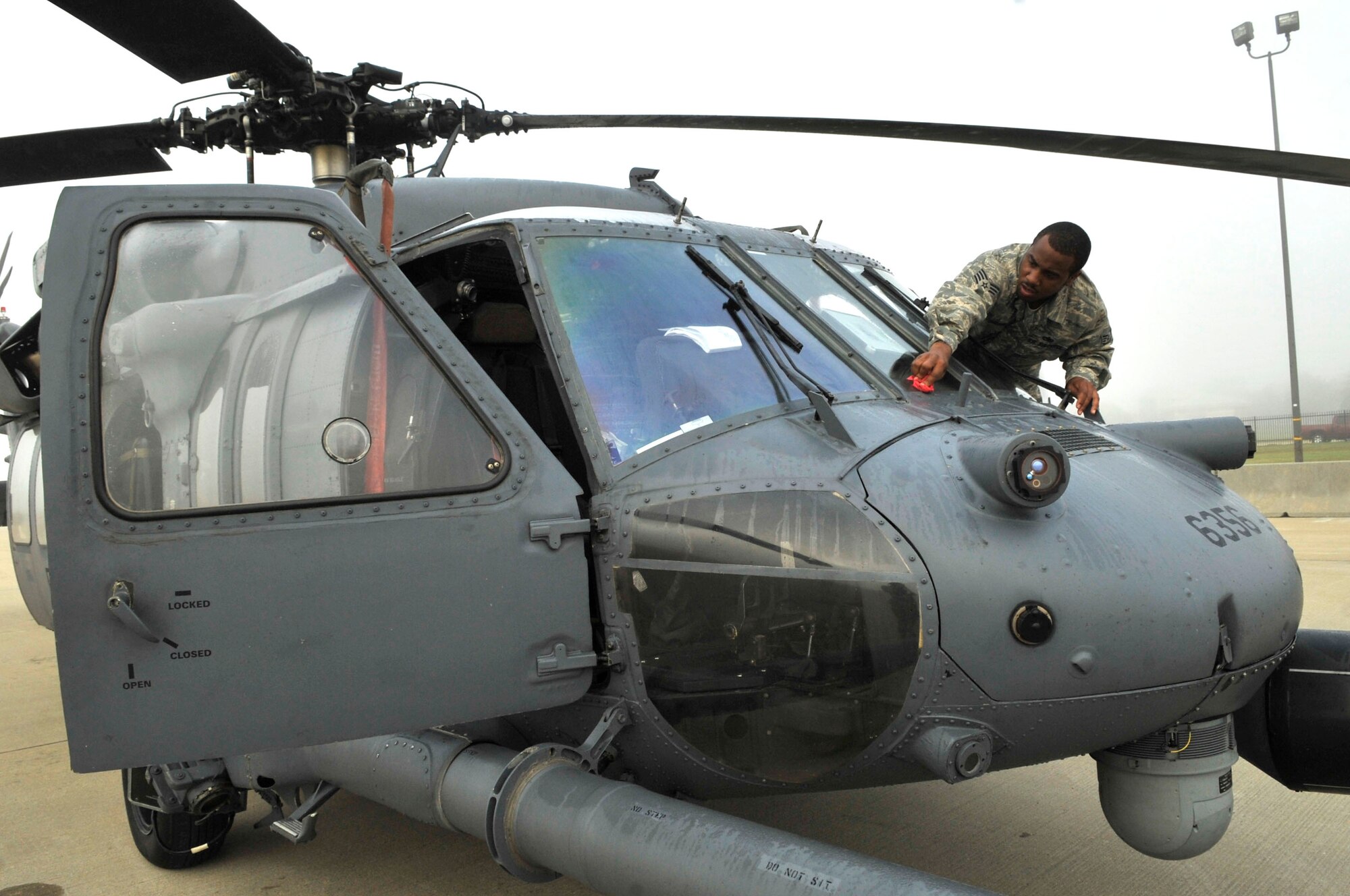 U.S. Air Force Staff Sgt. Anthony Wilson, 723rd Aircraft Maintenance Squadron avionics technician, cleans a window on an HH-60 Pave Hawk at Shaw Air Force Base, S.C., March 22, 2012. Wilson was preparing for a flight to Moody Air Force Base. (U.S. Air Force photo by Airman Nicole Sikorski/Released)