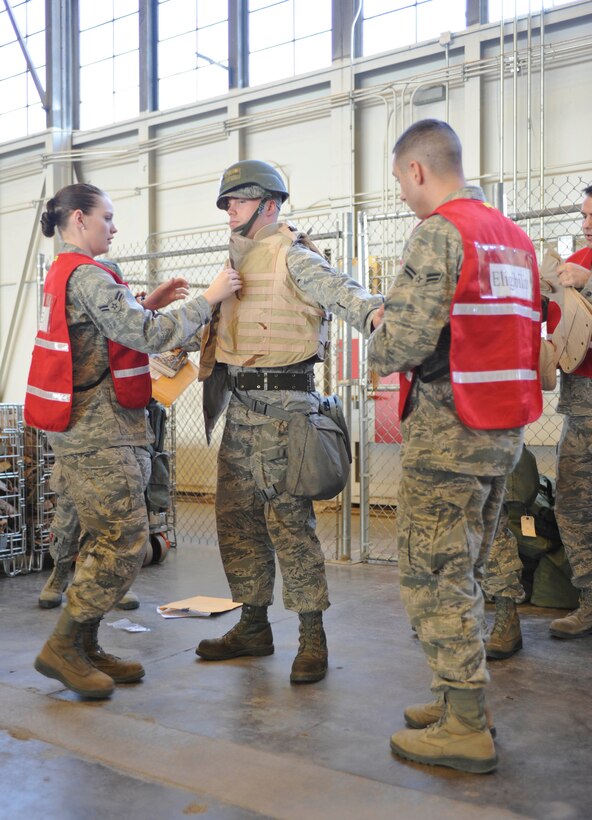 An Ellsworth Airman is fitted with body armor as they simulate leaving for a deployed location during the Phase I Operational Readiness Exercise at Ellsworth Air Force Base, S.D., March 14, 2012.  The ORE tested the ability of Airmen to deploy in response to a tasking.  (U.S. Air Force photo by Airman 1st Class Anania Tekurio/Released)