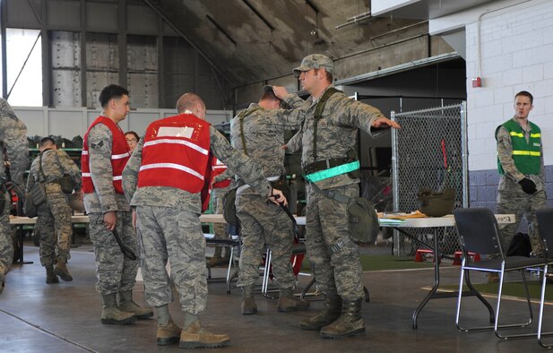 Airmen are searched and scanned in the Personnel Deployment Function line during the Phase I Operational Readiness Exercise at Ellsworth Air Force Base, S.D., March 14, 2012.  The searches ensure that all Airmen are in compliance with regulations and that Airmen do not possess any contraband or items not allowed in the processing center.  (U.S. Air Force photo by Airman 1st Class Anania Tekurio/Released)