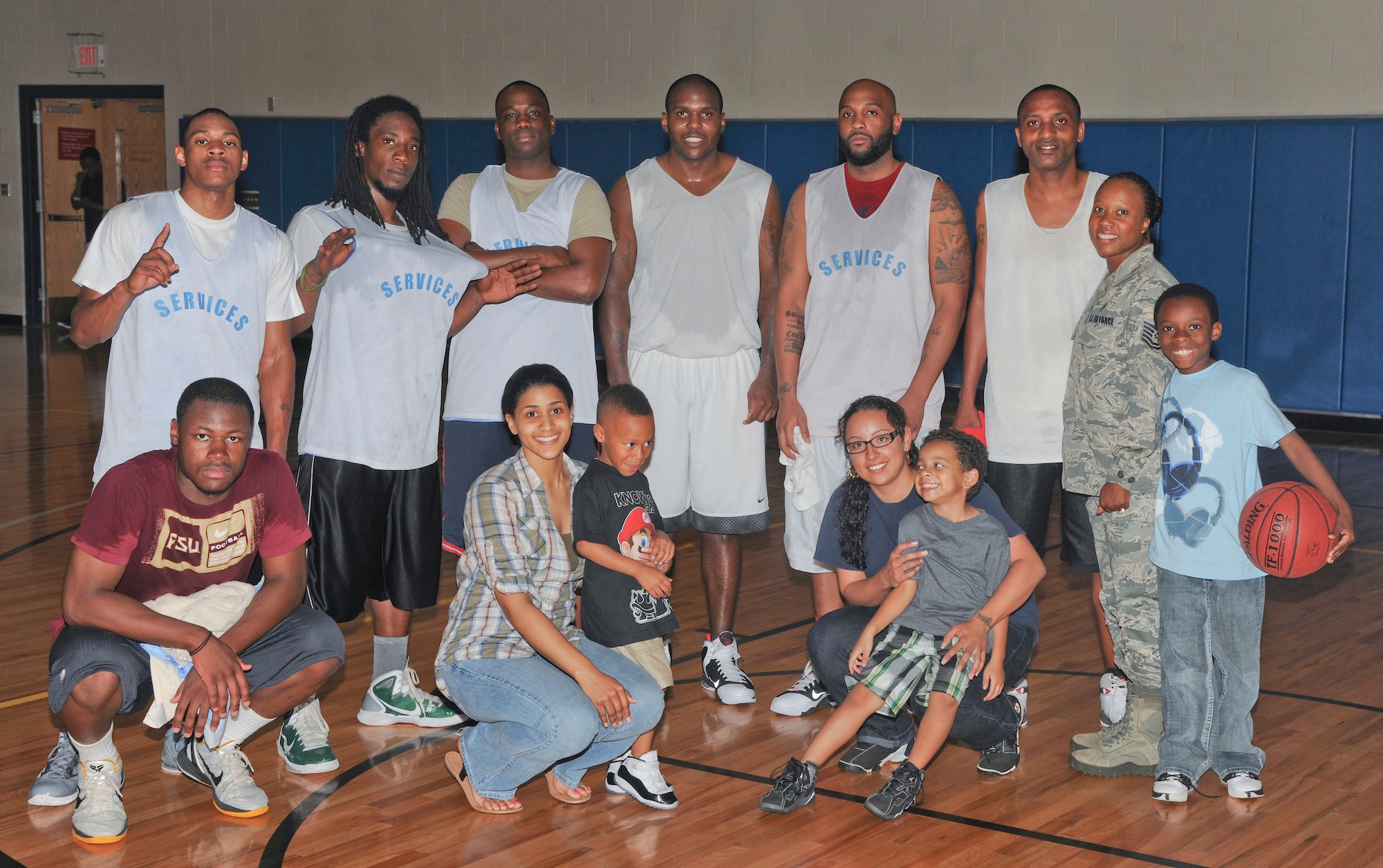 Members of the 23d Force Support Squadron pose with family and friends after going undefeated in the playoffs and beating the 23d Maintenance Operations Squadron in the intramural basketball championship game at Moody Air Force Base Ga., March 21, 2012. The 23d FSS won championship for the second with a final score of 55 to 51.  (U.S. Air Force photo by Airman 1st Class Paul Francis/Released)

