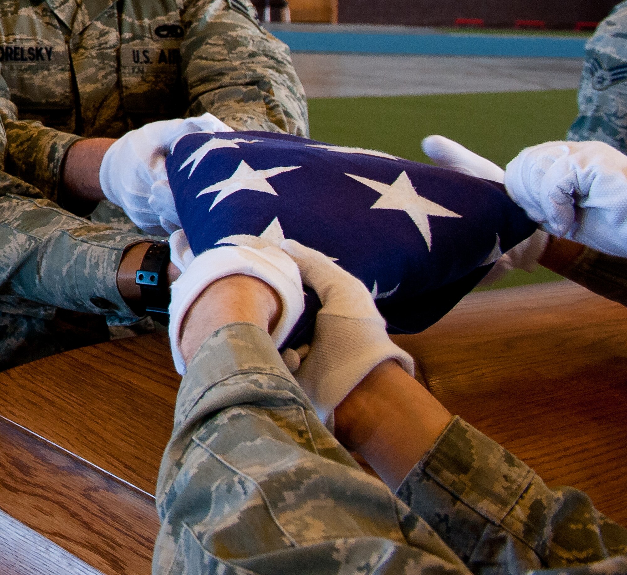 Ellsworth Honor Guard members ceremonially fold a U.S. flag during a funeral rehearsal sequence in the Pride Hangar at Ellsworth Air Force Base, S.D., March 19, 2012. Once the flag is property folded, the leader of the detail presents the flag to the next of kin as a way of thanking the servicemember and their family for their service to the country. (U.S. Air Force photo by Airman 1st Class Kate Thornton/Released)