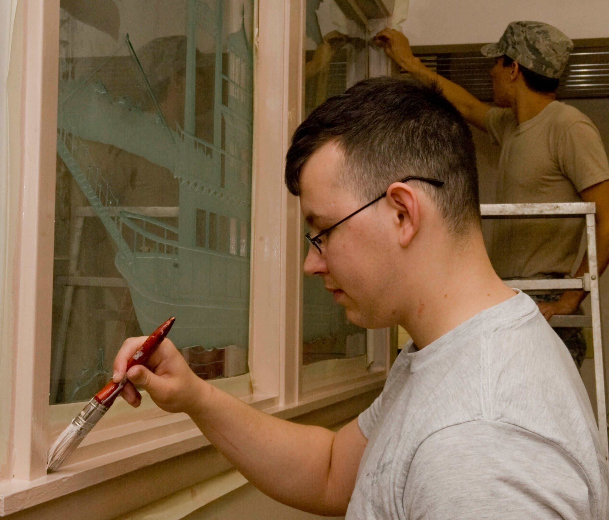Airmen 1st Class Marc Eisenmann and Christian Noe, 2nd Force Support Squadron, paint the trim of wall decorations in the Red River Dining Facility on Barksdale Air Force Base, La., March 20. The DFAC is scheduled to reopen April 2 after undergoing renovations and upgrades for the past several months. (U.S. Air Force photo/Senior Airman Kristin High)(RELEASED)