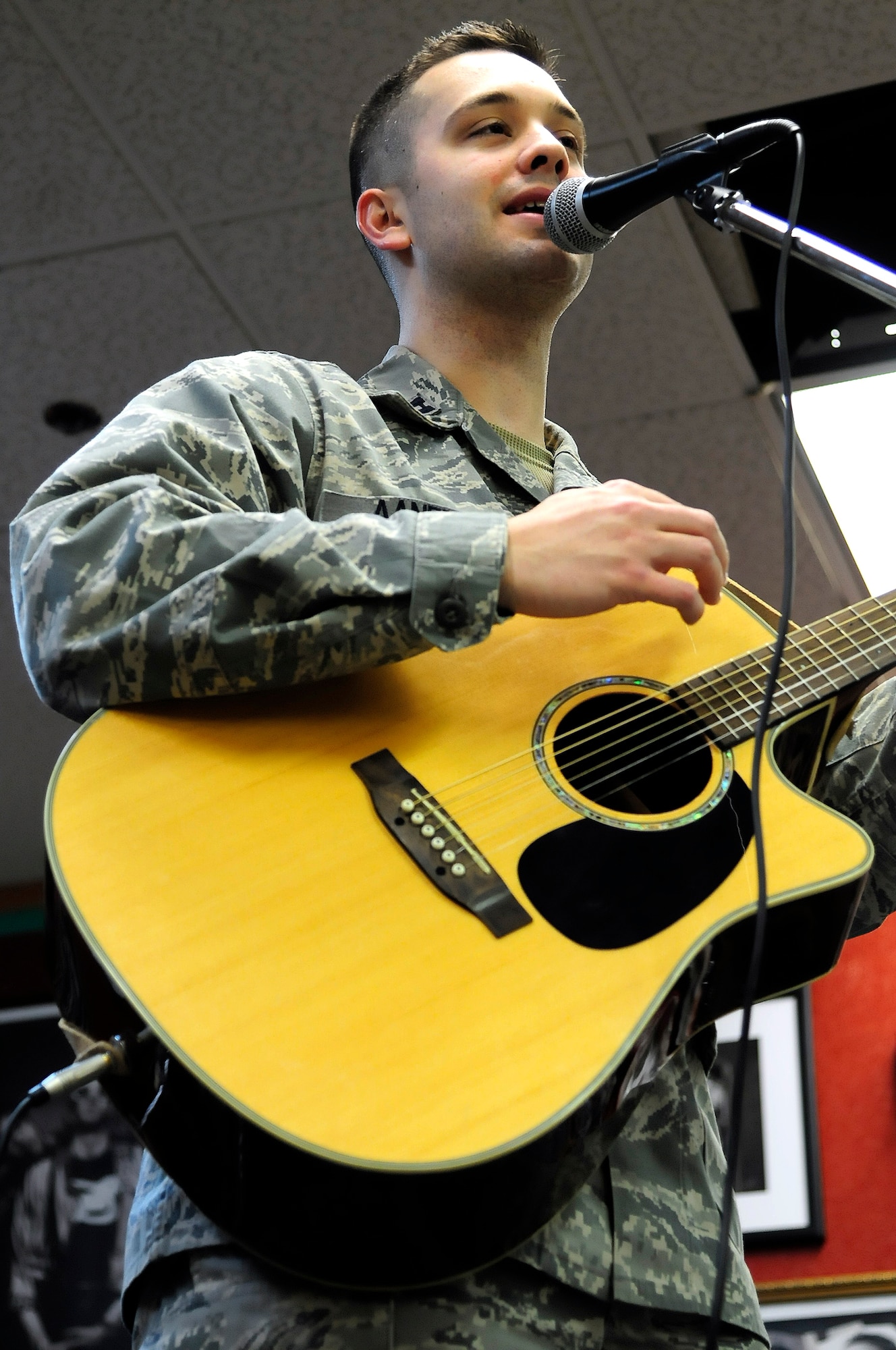U.S. Air Force Capt. Tim Aanerud, 18th Aircraft Maintenance Unit officer in charge, sings to memorize the lyrics to a song while practicing with the band Red Ball at the teen center here March 15, 2012. Aanerud is the lead singer and rhythm guitarist and will be performing at the Maintenance Professional of the Year banquet in April. (U.S. Air Force photo/Airman 1st Class Zachary Perras)