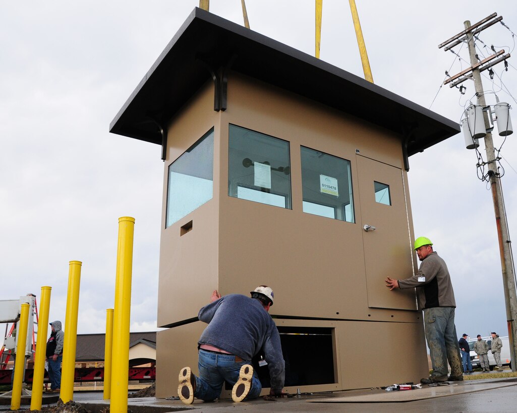 Workers guide the new Security Forces over watch booth into place near the main gate at Niagara Falls Air Reserve Station, NY on March 15, 2012. This new hardened facility will replace a guard booth which did not allow security forces a clear view of the main gate vehicle check. This new state of the art over watch has protective measures built into the booth to protect the guard on duty against hostile action, a higher vantage point and allows the individual to assist in deterring any unauthorized entry. (U.S. Air Force photo by Peter Borys)