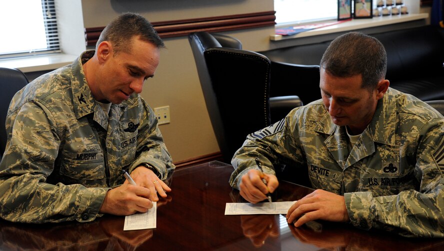 LAUGHLIN AIR FORCE BASE, Texas – Col. Tom Murphy, 47th Flying Training Wing commander, and Chief Master Sgt. Ray DeVite, 47th FTW command chief, donate to the 2012 Air Force Assistance Fund here March 13. The AFAF is a campaign that raises money for four charities that support military members: the Air Force Aid Society, Air Force Enlisted Village, Air Force Village and the General and Mrs. Curtis E. LeMay foundation. (U.S. Air Force photo/Airman 1st Class Nathan L. Maysonet)