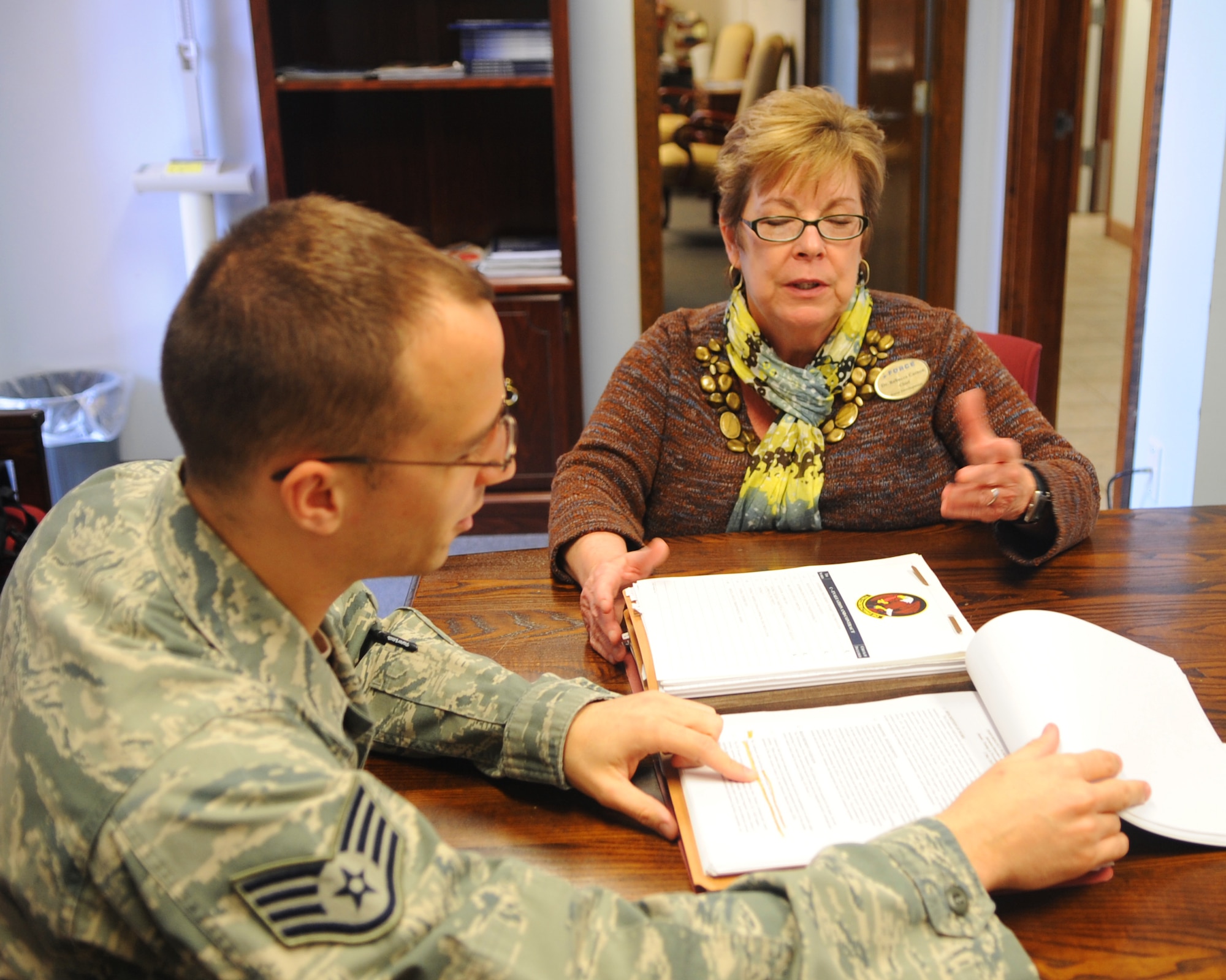 Staff Sgt. Kyle Kinder, left, 7th Contracting Squadron, goes over a performance work statement with Mrs. Rebecca Carson, right, 7th Force Support Squadron March 20, 2012, at Dyess Air Force Base, Texas. Carson is currently working with 7 Cons on a contract with the education center and the base library. (U.S. Air Force photo by Airmen 1st Class Cierra Bullock/ Released)