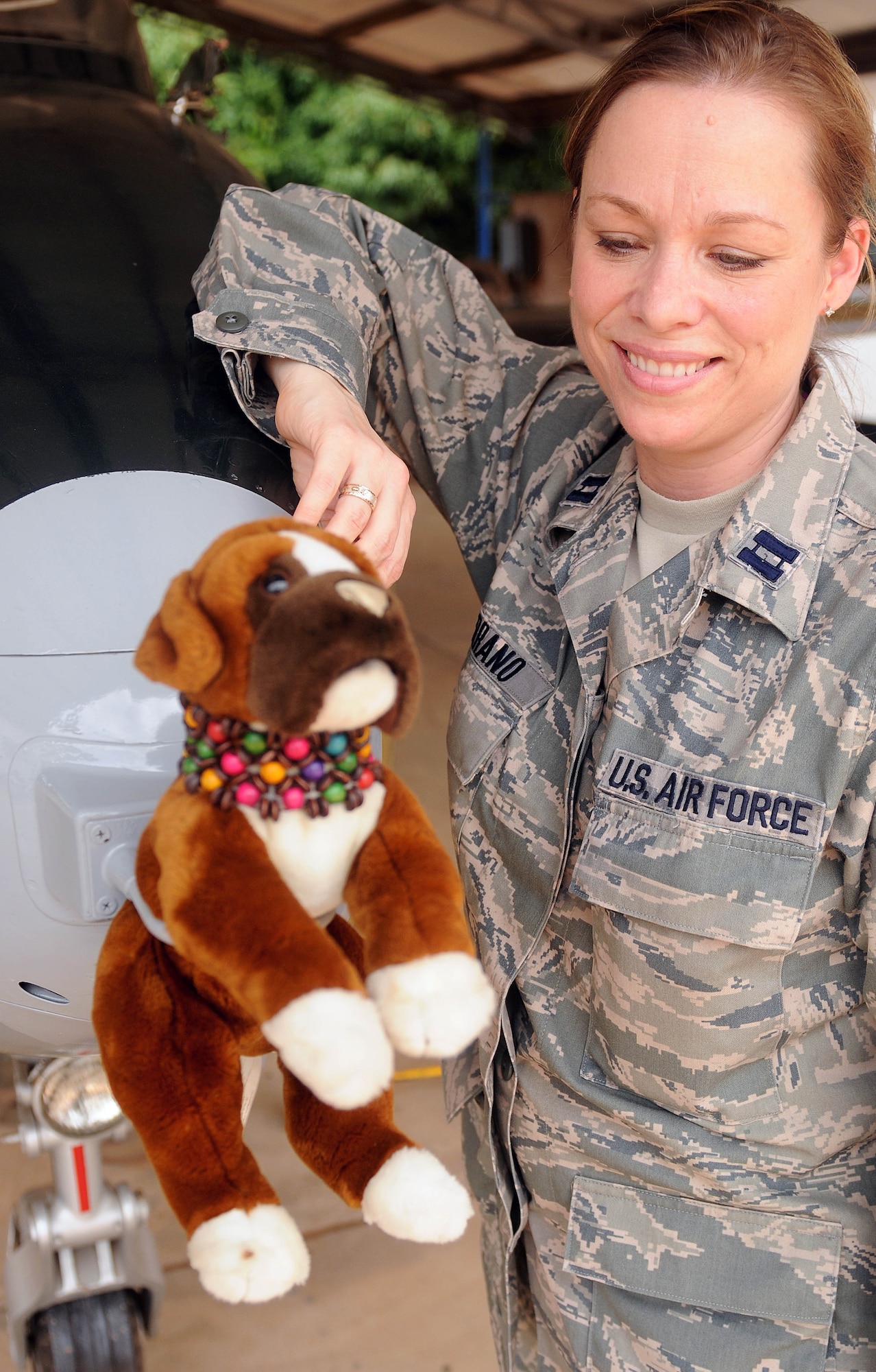 ACCRA, Ghana -- Captain Shana Serrano, U.S. Air Forces in Africa interpreter, poses with Lola, the stuffed animal, by an aircraft March 16 at Camp Burma here. Serrano is here as an interpreter for the African Partnership Flight 12-2, which is a military-to-military event increasing the capabilities of U.S., Ghanaian, Nigerian, Togolese, Senegalese and Benin Air Forces through partnership building. Serrano brought Lola to take photos with around Ghana and with her fellow comrades from all Air Forces participating in APF 12-2 so that her daughter can see the kind of work she's doing in Africa. (U.S. Air Force photo by Senior Airman Natasha Stannard/Released)