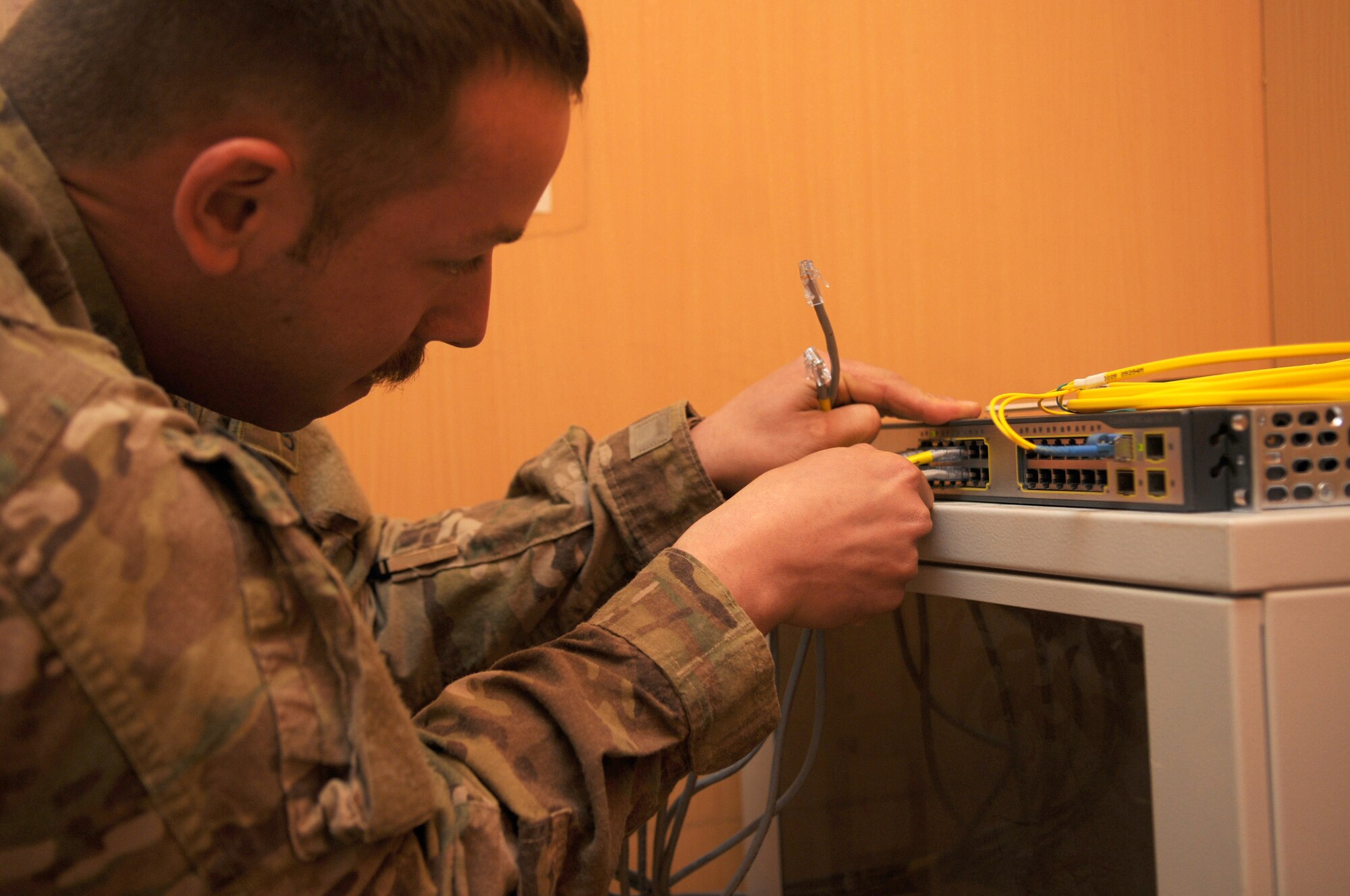 Staff Sgt. Brian McGahey, network infrastructure technicians with the 445th Air Expeditionary Advisory Squadron, connects cables to a server during an initial setup for a newly created English language immersion center, Shindand Air Base, Afghanistan, March 20, 2012. McGahey is assigned to the 445th AEAS as part of the communications sustainment team that manage all communication capabilities of the 838th Air Expeditionary Group advisors. (U.S. Air Force photo by Staff Sgt. Nadine Y. Barclay)