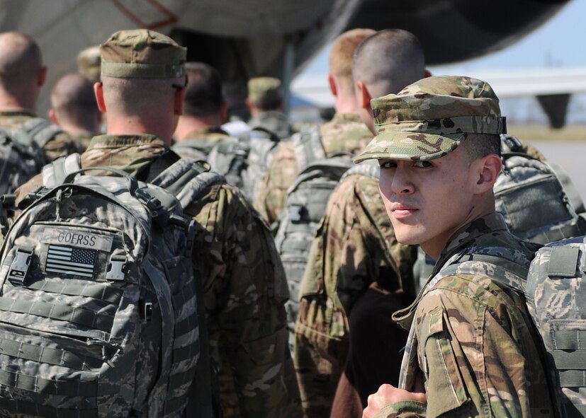 Airman 1st Class Jeremy Quesada, of the 174th Fighter Wing Security Forces Squadron, glances back to friends and family that are seeing him off at Hancock field in Syracuse NY, on 21 March 2012.  Quesada along with 30 174th FW security forces airman are deploying to Afghanistan for six months. (photo by TSgt Ricky Best/RELEASED)