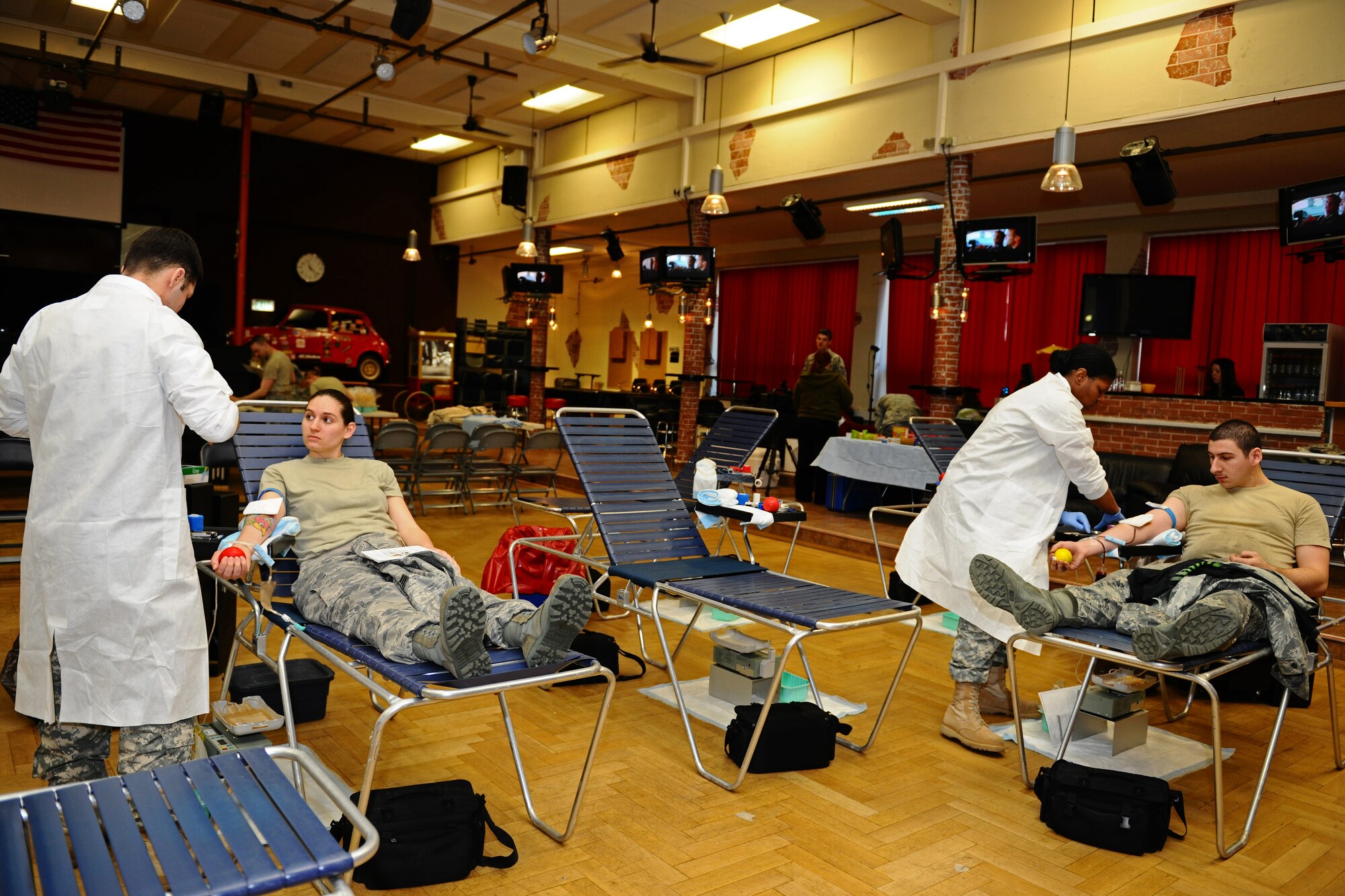 SPANGDAHLEM AIR BASE, Germany – Landstuhl Regional Medical Center medical lab technicians receive blood from donors during the Spangdahlem Community Blood Drive at the Brick House here March 21. Spangdahlem members donated blood to the Armed Services Blood Program, which distributes blood products to service members and their families around the world. (U.S. Air Force photo by Airman 1st Class Matthew B. Fredericks/Released)