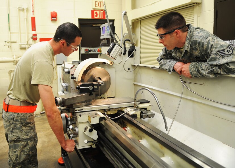Airman 1st Class Joshua Greer, 7th Equipment Maintenance Squadron, performs turning operations on a lathe while Staff Sgt. Kevin Parnell, 7th EMS, supervises the procedure March 20, 2012, at Dyess Air Force Base, Texas. 7th EMS offers many services such as manufacturing, repairing and welding operations. (U.S. Air Force photo by Airman 1st Class Cierra Bullock/ Released)