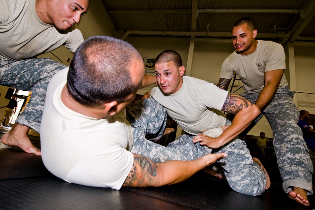 Army Spc. Ernesto Ventura works with combatives team members Sgt ...