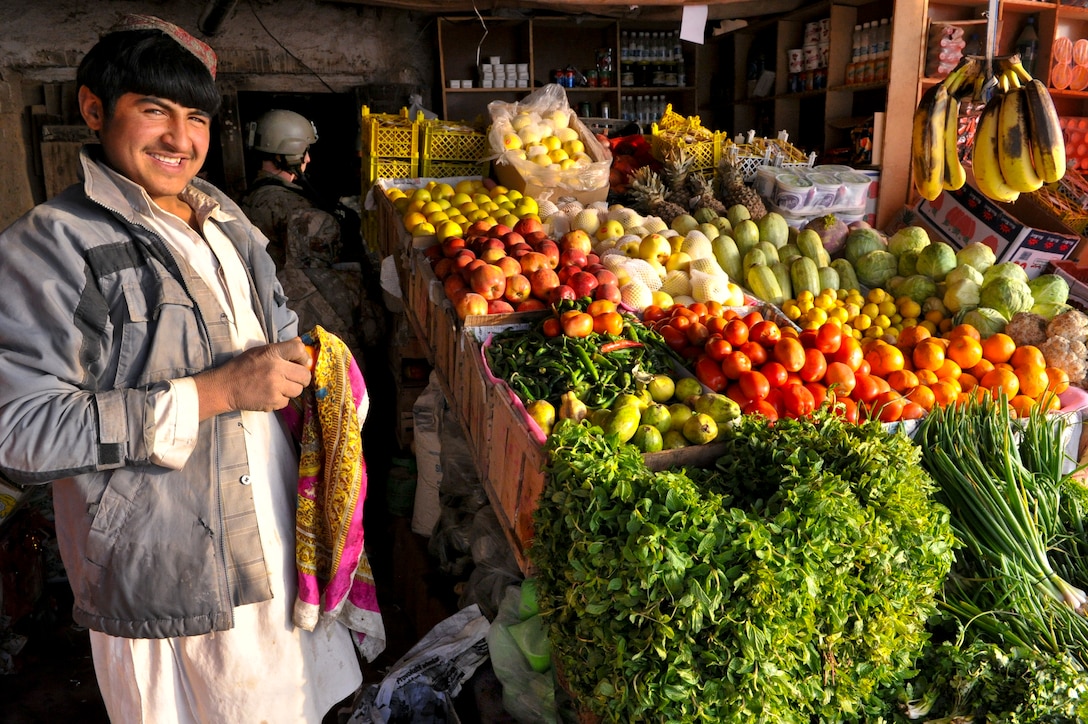 An Afghan merchant waits at the entrance of his market, selling produce at a local bazaar in the Muqer district, Ghazni province, Afghanistan, March 21, 2012.  Coalition forces conducted a dismounted patrol to engage merchants, villagers and  key leaders in the area following an attack by insurgents.