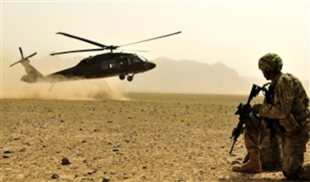 U.S. Army Sgt. Paul Jordan, a medic assigned to the 25th Combat Aviation Brigade, provides security as an UH-60 Black Hawk helicopter arrives to extract his team and members of 2nd Afghan National Civil Order Patrol Special Weapons and Tactics Team in Kandahar province, Afghanistan, on March 16, 2012.  
