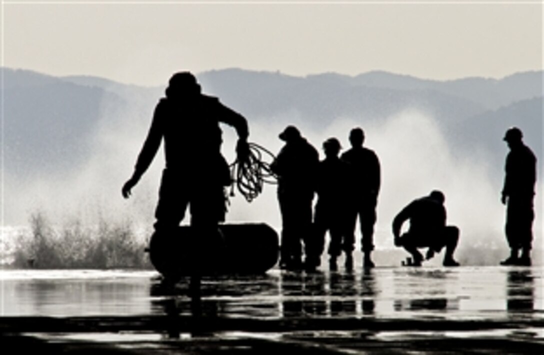 U.S. Navy sailors prepare the well deck of the amphibious assault ship USS Bonhomme RIchard to receive visitors via the stern gate in the Pacific Ocean, March 21, 2012. The ship is engaged in operations to relieve USS Essex in Sasebo, Japan.