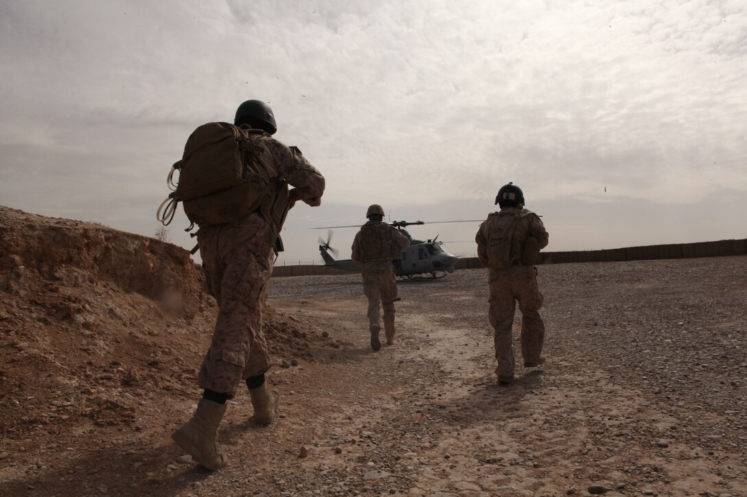 Members of National Interdiction Unit Team 10 move to board a helicopter before a raid on a suspected opium production facility here, March 22, 2012. The raid was part of Operation Psarlay Taba, a partnered counternarcotics operation conducted by the NIU and 2nd Battalion, 9th Marine Regiment to disrupt narcotics trafficking around Helmand province's Marjah district. The partnered force captured around 26,000 pounds of assorted opium products over the course of the four-month operation.
