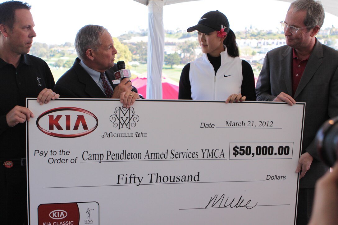 George Brown, executive director of the Camp Pendleton Armed Services YMCA, accepts a donation of $50,000 from professional golfer Michelle Wie and Tom Loveless (far right), vice-president of sales for Kia Motors America, during the Ladies Professional Golf Association Tour at La Costa Resort and Spa, Mar. 22. The donation will go towards the ASYMCA’s Operation Hero program, which provides after school mentoring and tutoring to elementary school-aged children free of charge.