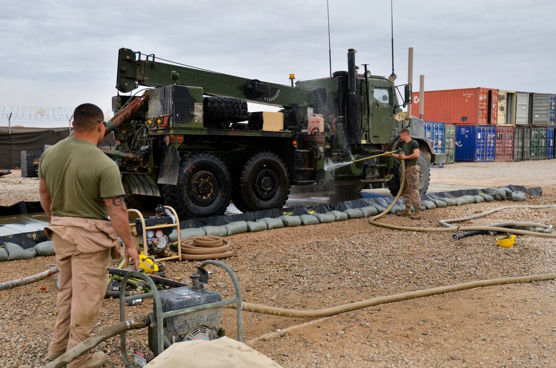 Sgt. Kevin A. Rodriguez, (left), a basic water support technician, Support Company, Combat Logistics Battalion 4, 1st Marine Logistics Group (Forward), oversees a test–run during construction of the CLB-4’s washrack, March 22. Lance Cpl. Mark A. Stevenson, a wrecker operator, Support Co., cleaned the vehicle during the test. The washrack is designed to support the efficient cleaning of CLB-4’s tactical vehicles.