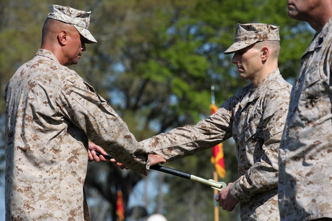 Brig. Gen. Thomas A. Gorry, commanding general, Marine Corps Installations East, passes the Sword of Office to Sgt. Maj. Ernest K. Hoopii, the new sergeant major for MCIEAST, in a ceremony at Marine Corps Base Camp Lejeune, March 23.