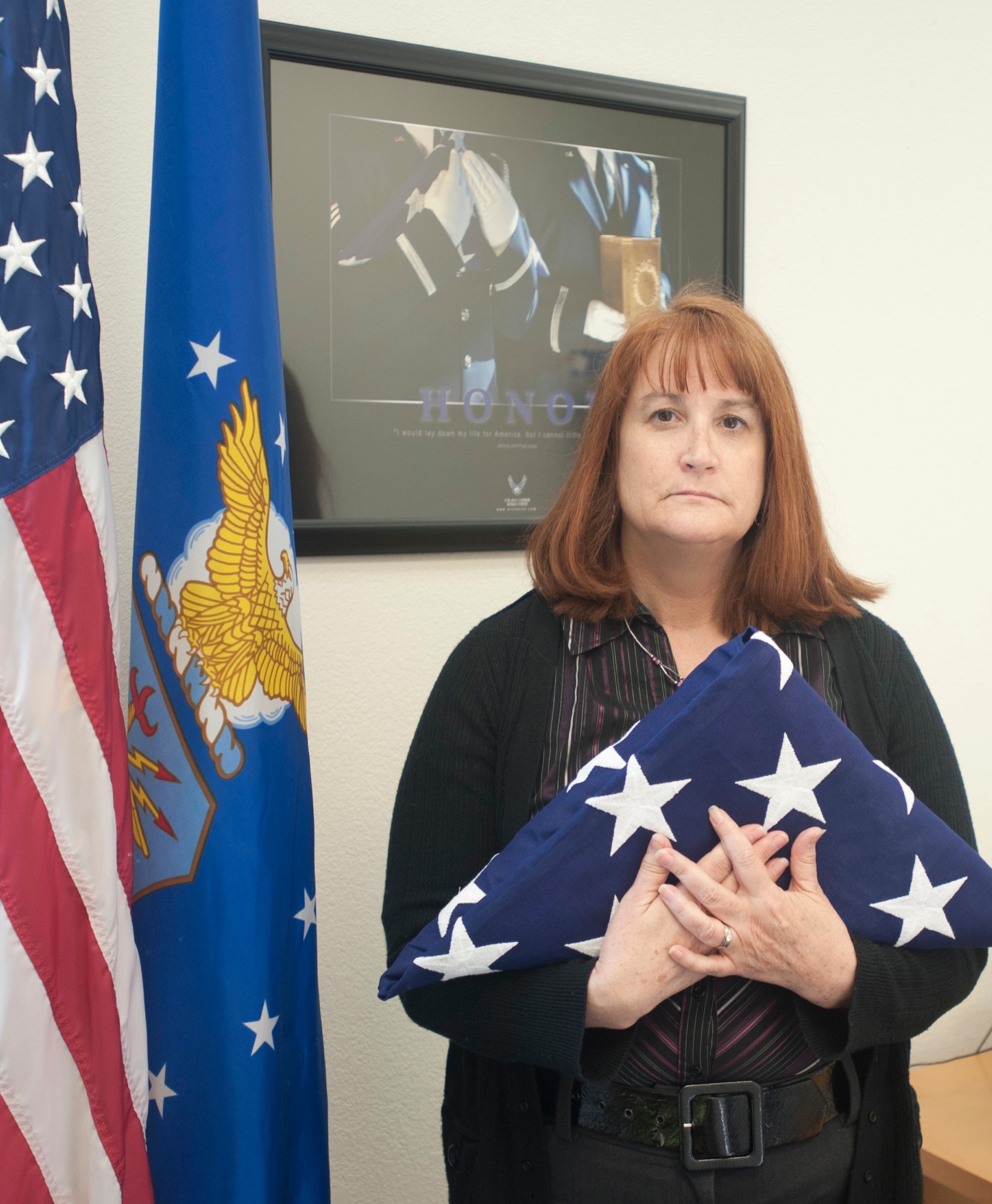 Tara Sutherland, 60th Force Support Squadron mortuary affairs officer, poses with a folded flag Wednesday at the Honor Guard building. Sutherland handles active-duty deaths at Travis. (U.S. Air Force photo/Airman 1st Class Nicole Leidholm)