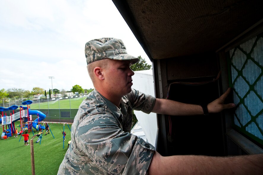 Airman Brett Bibel, a student at the Navy School of Explosive Ordnance Disposal, replaces an air conditioning filter at the Boys and Girls Club in Fort Walton Beach, Fla., March 21.  He and four other EOD students used their break from class to help clean up areas of the club.  (U.S. Air Force photo/Samuel King Jr.)