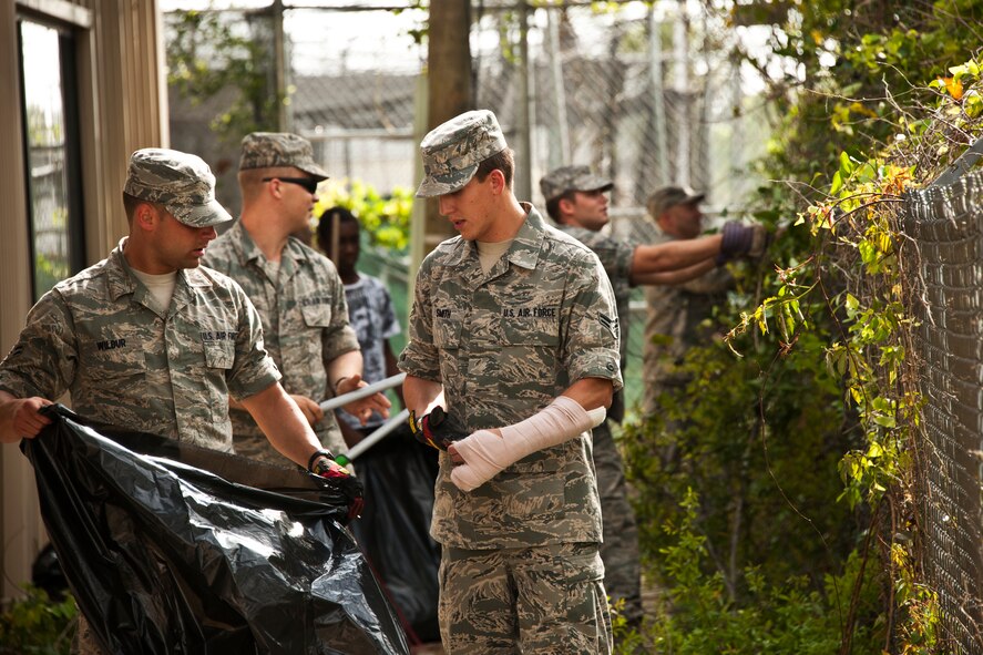 Student Airmen from the Navy School of Explosive Ordnance Disposal, help clean up around the outside of the Boys and Girls Club in Fort Walton Beach, Fla., March 21.  During a break in their class schedule, the Airmen spent two hours cleaning and completing odd jobs for the local club.  (U.S. Air Force photo/Samuel King Jr.)
